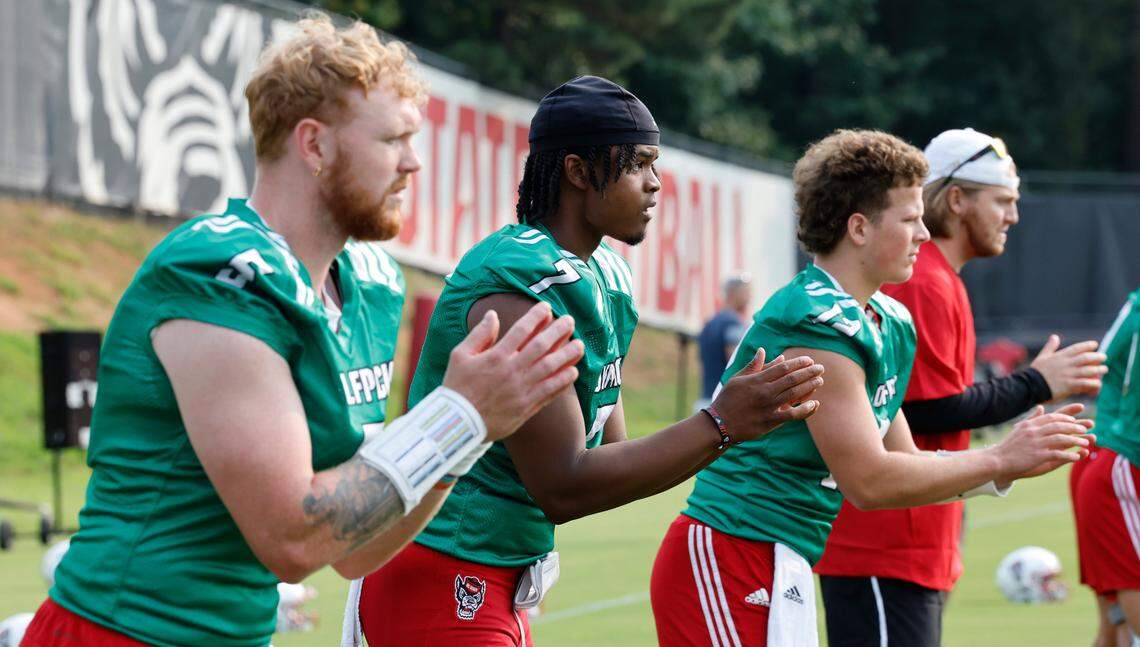 From left, N.C. State quarterbacks Brennan Armstrong (5), MJ Morris (7) and Lex Thomas (12) runs drills during the Wolfpack’s first fall practice in Raleigh, N.C., Wednesday, August 2, 2023.