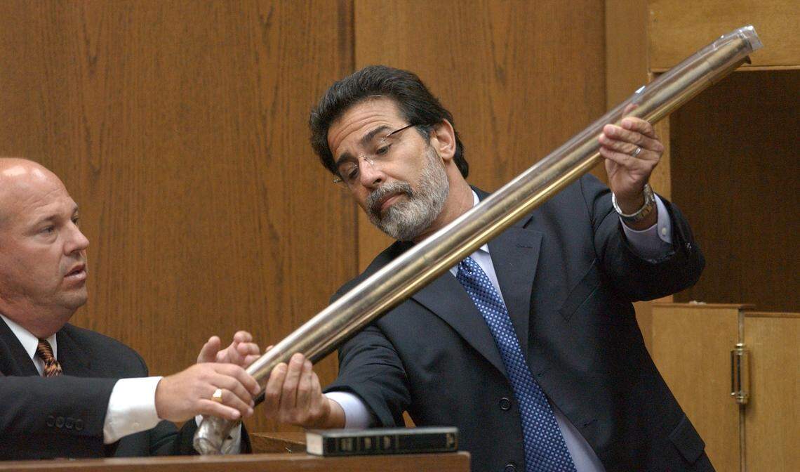 PETERSON2.NE.092303.HLL -- DURHAM -- Peterson lead defense attorney David Rudolf (cq), right, holds the prosecution’s evidence, the blow poke of Candace Zamperini up next to a plastic-encased blow poke for comparison for Durham detective Art Holland (cq), left, to examine during Tuesday am’s testimony. The defense surprised the prosecution with the submission of the second blow poke alleged to be the one long missing from the Michael Peterson home.Holland is Durham PD’s lead detective in the investigation of the death of Michael Peterson’s wife, Kathleen Peterson in Dec., 2001.Candace Zamperini is the sister of Kathleen Peterson and gave the missing blow poke to the Petersons as a gift years ago.STAFF/HARRY LYNCH