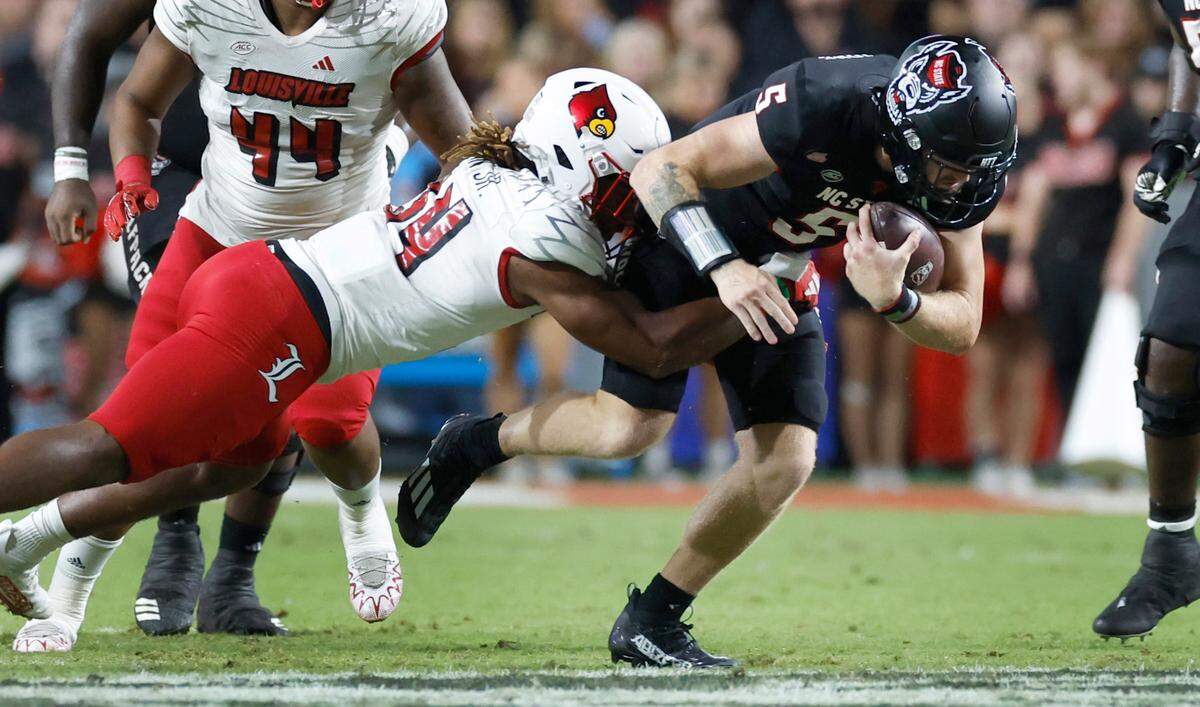 N.C. State quarterback Brennan Armstrong (5) is tackled by Louisville linebacker TJ Quinn (34) during the first half of N.C. State’s game against Louisville at Carter-Finley Stadium in Raleigh, N.C., Friday, Sept. 29, 2023.