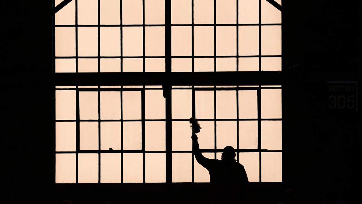 A fan is silhouetted against a window in Hinkle Fieldhouse before a Sweet 16 game between UCLA and Alabama in the NCAA men’s college basketball tournament in Indianapolis, Sunday, March 28, 2021. 