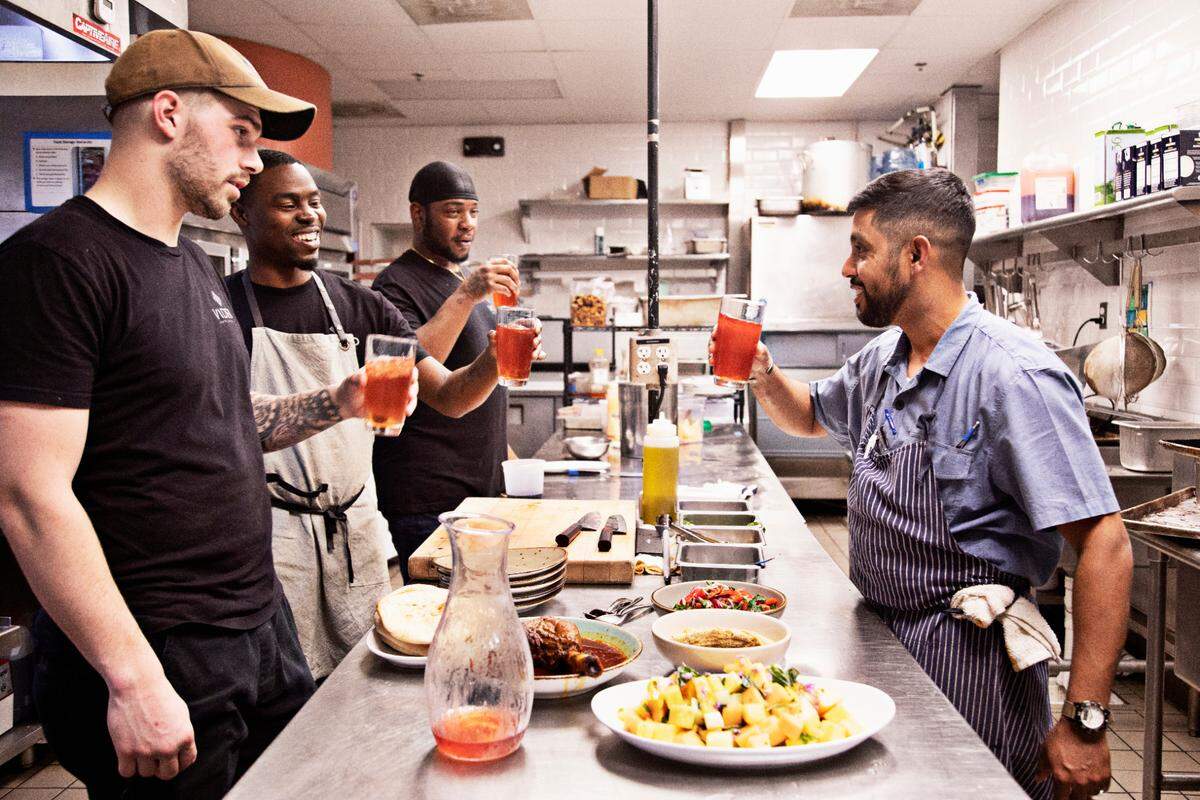 Vidrio chef Saif Rahman, right, raises a glass with kitchen staff during a short break during dinner service on Tuesday, April 26, 2022, to break fast. Rahman fasts for 14 hours daily during the month of Ramadan and is not able to break his fast until sundown which occurs during dinner service.