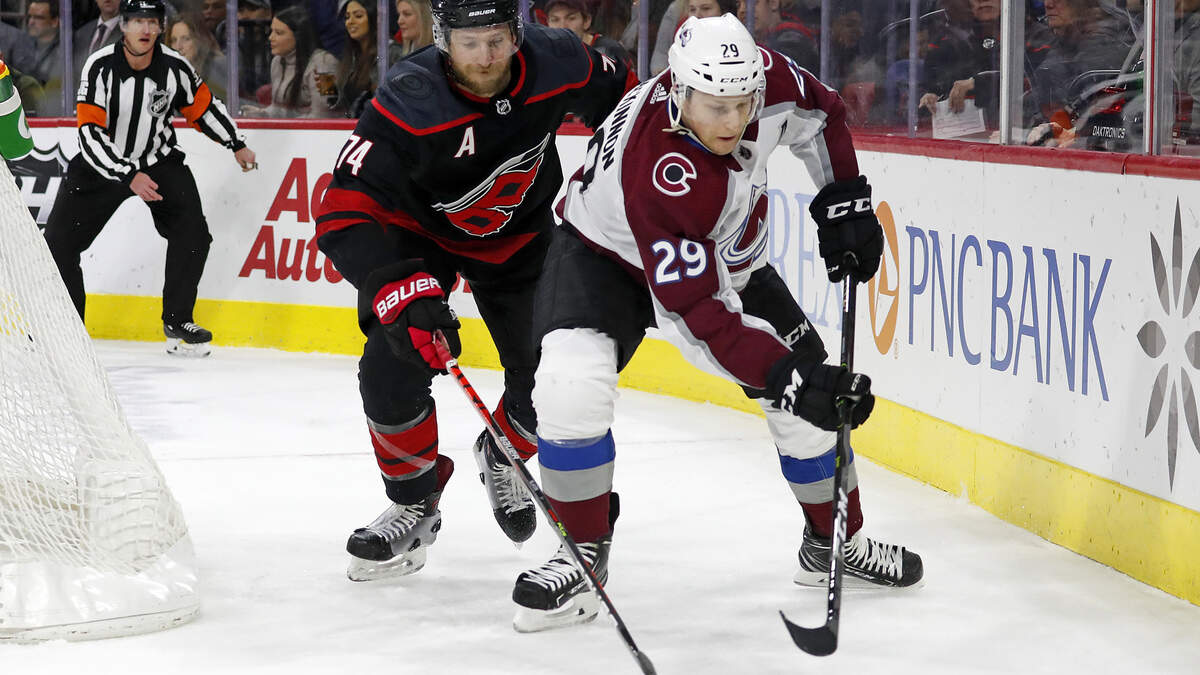 Colorado Avalanche’s Nathan MacKinnon (29) vies with Carolina Hurricanes’ Jaccob Slavin (74) for the puck during the first period of an NHL hockey game in Raleigh, N.C., Friday, Feb. 28, 2020. (AP Photo/Karl B DeBlaker)