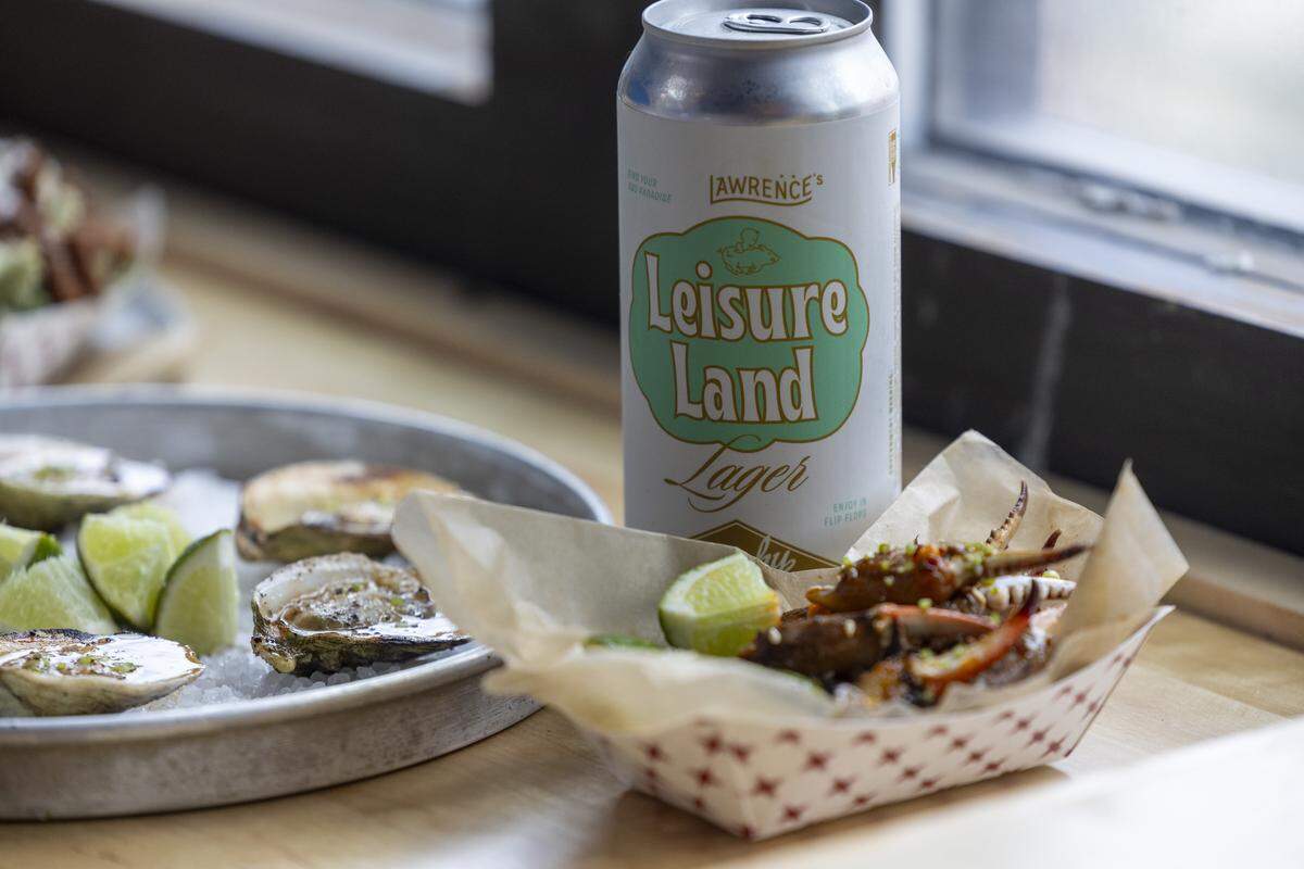 Lawrence Barbecue serves seafood including oysters and crab claws, photographed alongside a can of Lawrence’s Leisure Land Lager from Trophy Brewing.