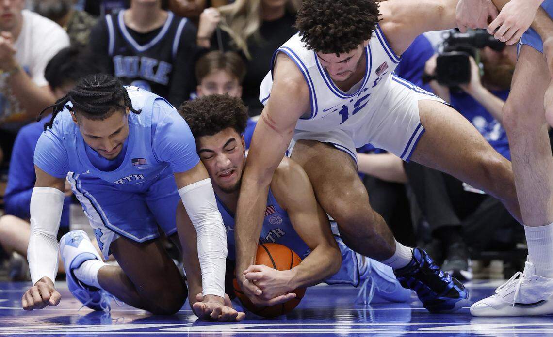 North Carolina's Derek Dixon (3) pulls in the loose ball as Duke’s Cameron Boozer (12) and North Carolina's Jarin Stevenson (15) also go after the ball during the first half of Duke’s game against UNC at Cameron Indoor Stadium in Durham, N.C., Saturday, March 7, 2026.