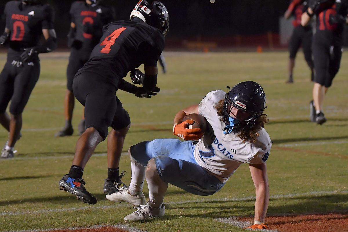 Millbrook's Quentin Cypher (4) falls across the goal line past Rolesville's Derion Newborn (4) for the touchdown during the first half. The Millbrook Wildcats and the Rolesville Rams met in a conference football game in Rolesville, N.C. September 26, 2025