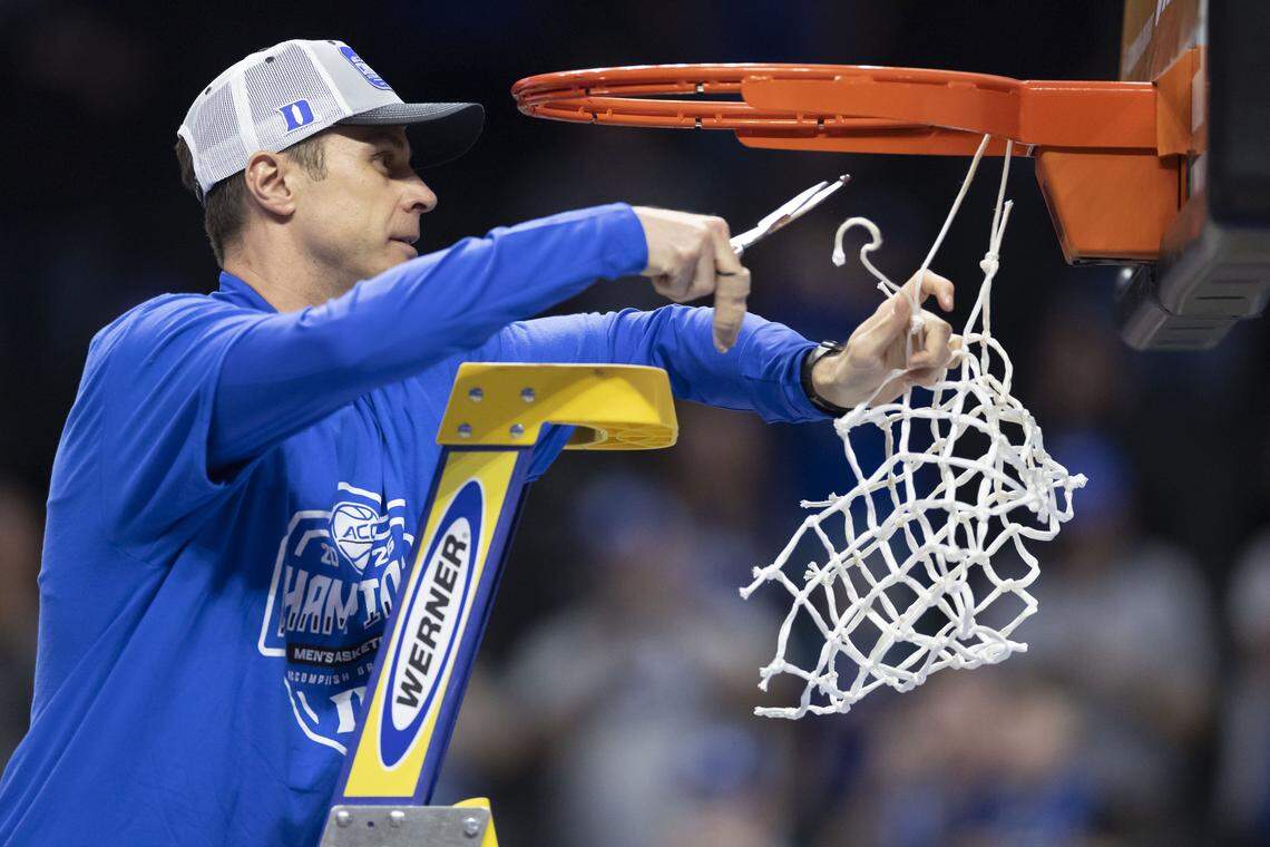 Duke coach Jon Scheyer cuts down the net following the Blue Devils’ 74-70 victory over the Virginia Cavaliers on Saturday, March 14, 2026, during the ACC Tournament Championship at Spectrum Center in Charlotte,  N.C.