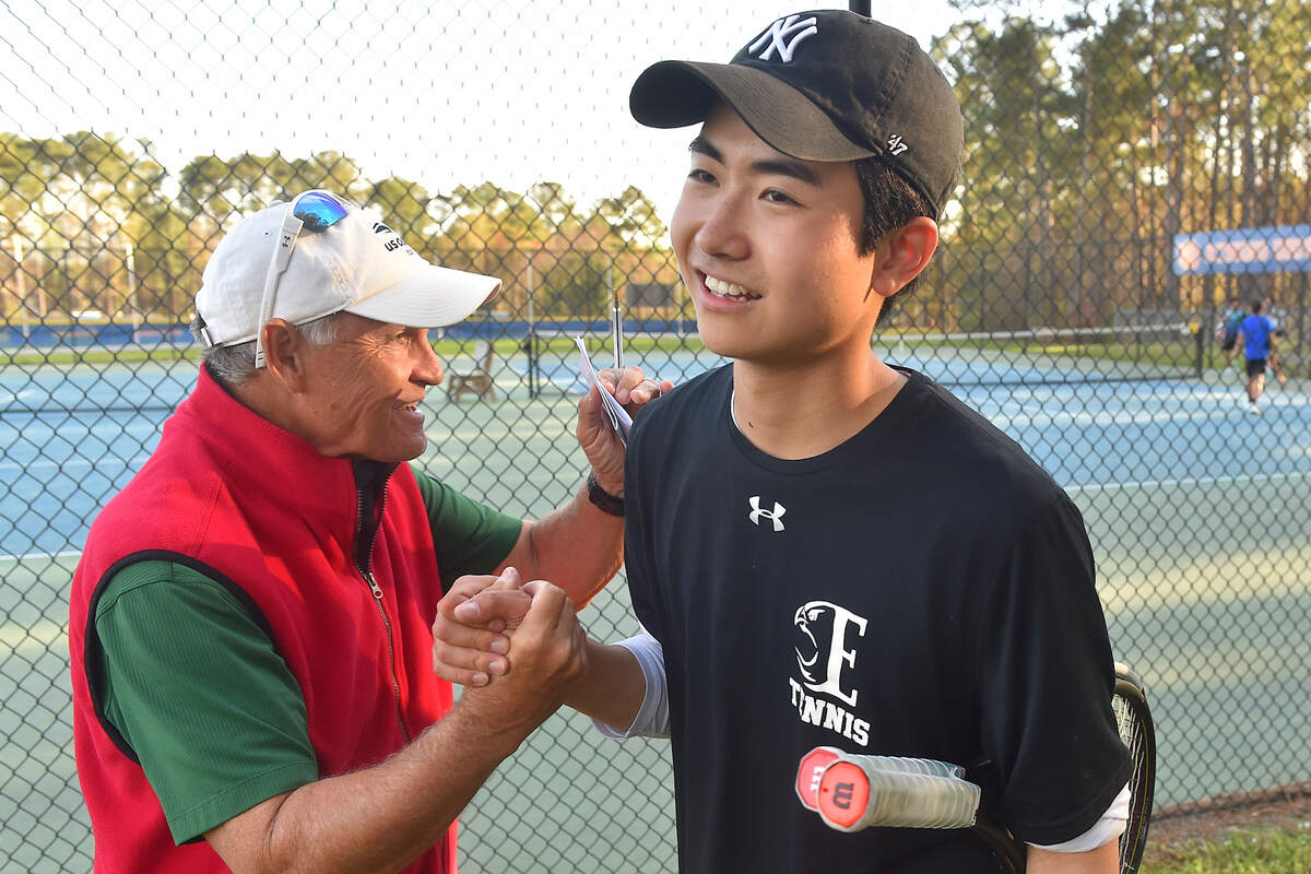 Enloe Tennis head congratulates William Chen after his victory in doubles over Athens Drive. Enloe Tennis head Coach Steven Spivey gets his 1100th career victory with a win over Athens Drive High in Raleigh, N.C. on March 25, 2022.
