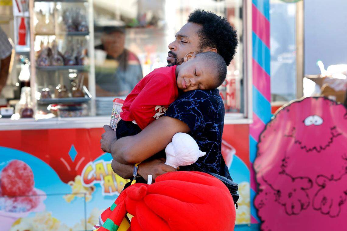 Aaron Bumphus carries his son Kayden, 2, while they walk around the N.C. State Fair in Raleigh, N.C., Thursday, Oct. 12, 2023.