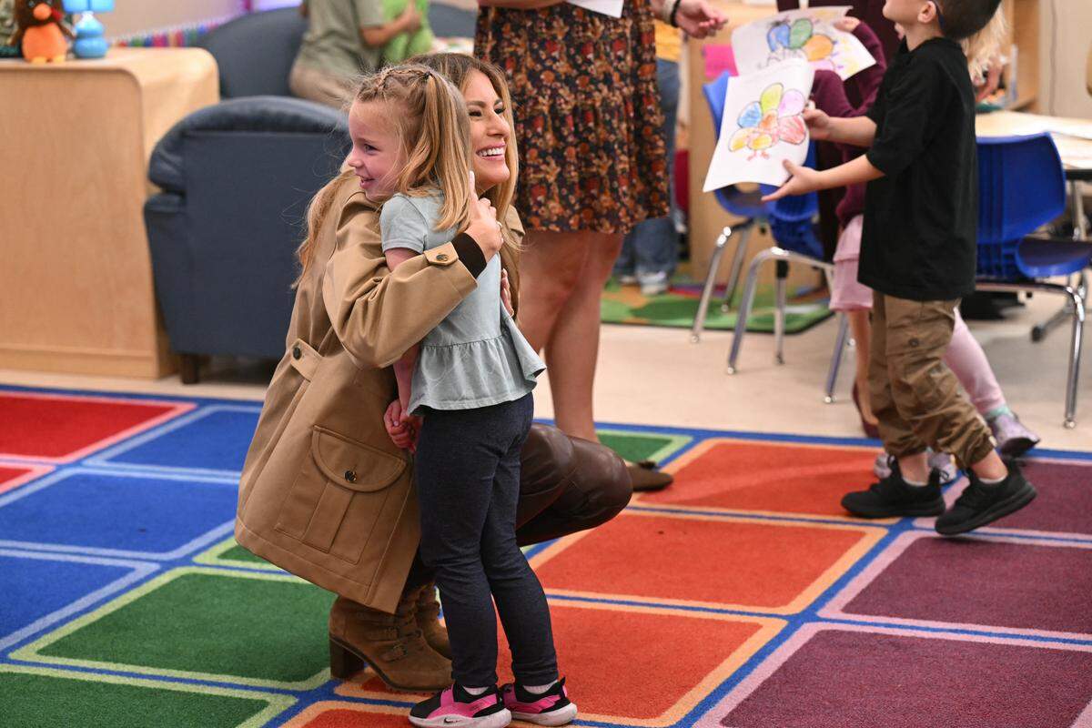 First Lady Melania Trump hugs  a student at DeLalio Elementary School at Marine Corps Air Station New River in Jacksonville, North Carolina, November 19, 2025, as they travel to visit military families. 