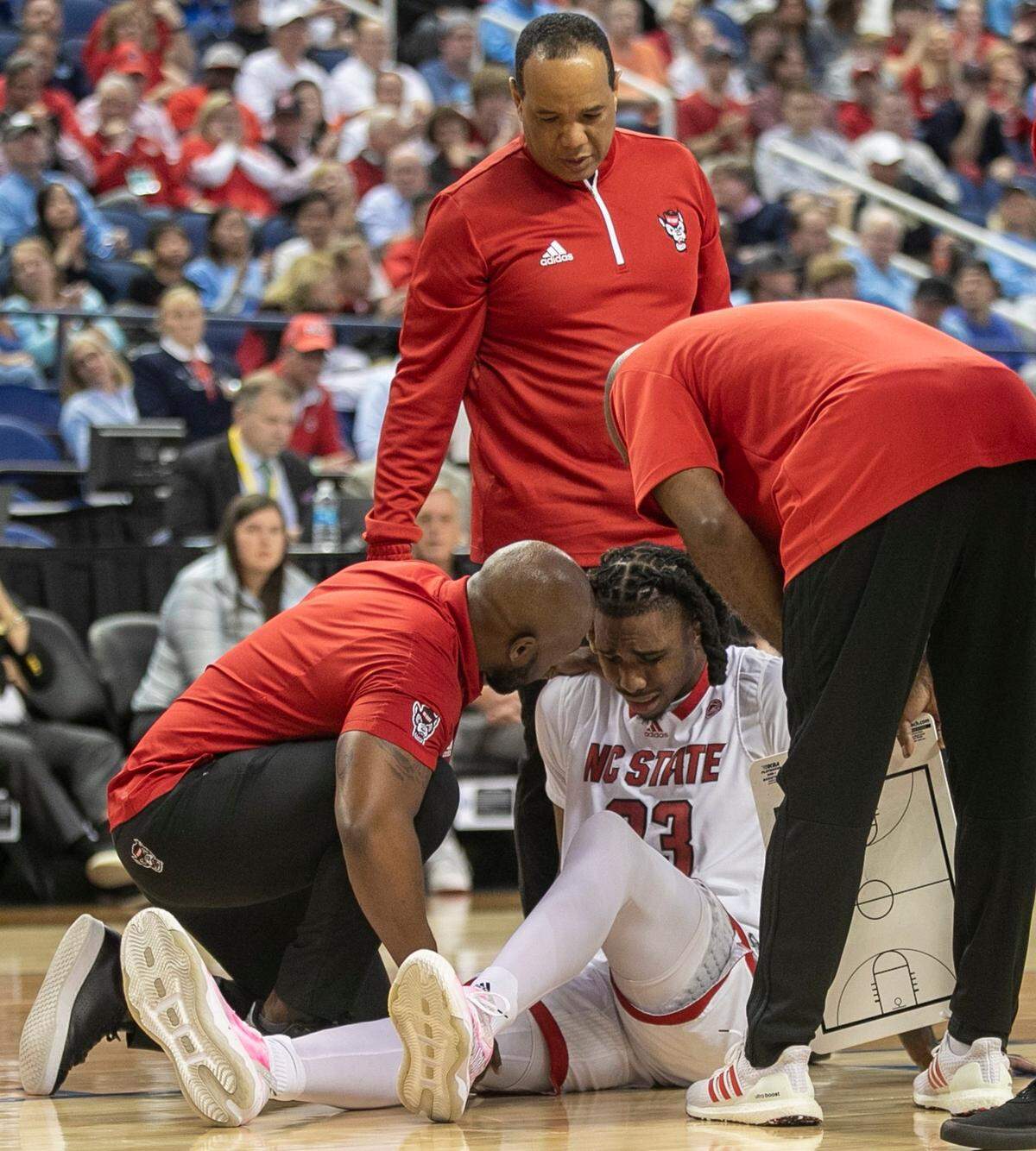 N.C. State coach Kevin Keatts looks on as trainers attend to Greg Gantt (23) after the was injured in the first half against Virginia Tech in the second round of the ACC Tournament on Wednesday, March 8, 2023 at the Greensboro Coliseum in Greensboro, N.C.