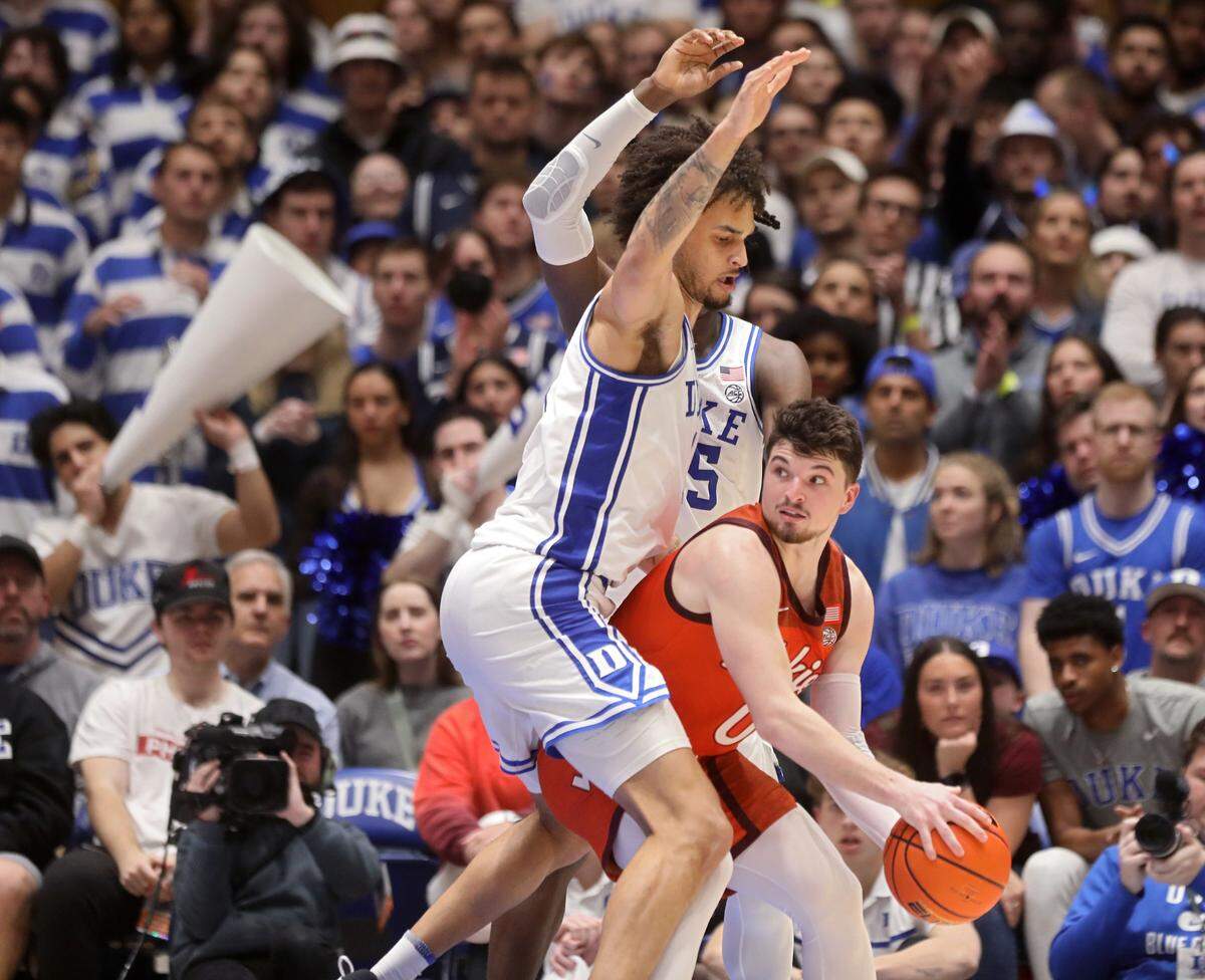 Virginia Tech’s Hunter Cattoor looks to pass around the defense of Duke’s Dereck Lively II and Mark Mitchell during the second half of the Blue Devils’ 81-65 win over Virginia Tech on Saturday, Feb. 25, 2023, at Cameron Indoor Stadium in Durham, N.C.
