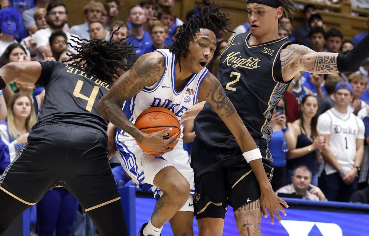Duke’s Isaiah Evans (3) drives between UCF’s Jamichael Stillwell (4) and Riley Kugel (2) during the second half of Duke’s 96-71 exhibition victory over UCF at Cameron Indoor Stadium in Durham, N.C., Tuesday, Oct. 21, 2025.