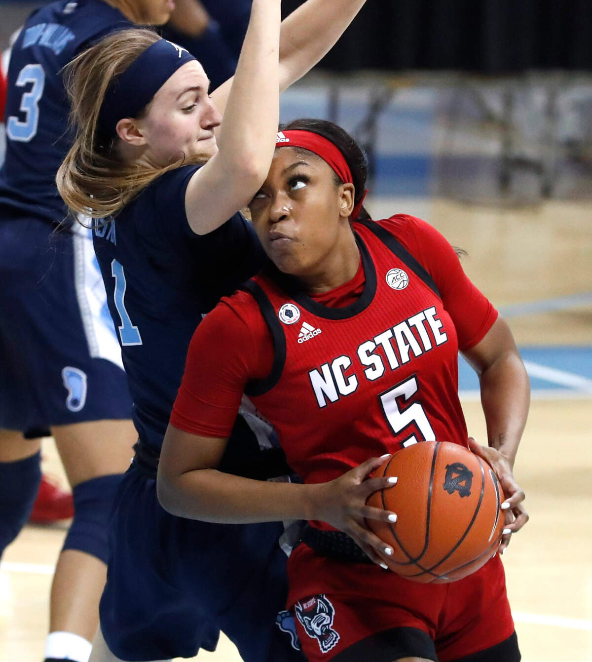 N.C. State’s Jada Boyd (5) looks for room as North Carolina’s Alyssa Ustby (1) defends during the first half of N.C. State’s game against UNC at Carmichael Arena in Chapel Hill, N.C., Sunday, February 7, 2021.