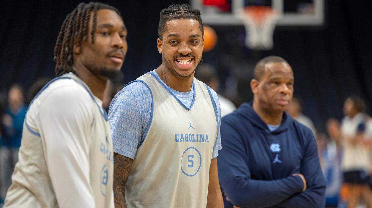 Flanked by teammate Jae’Lyn Withers (24) and coach Hubert Davis, North Carolina’s Armando Bacot (5) is all smiles during the team workout ahead of their NCAA Tournament game against Wagner on Wednesday, March 20, 2024 at Spectrum Center in Charlotte, N.C.