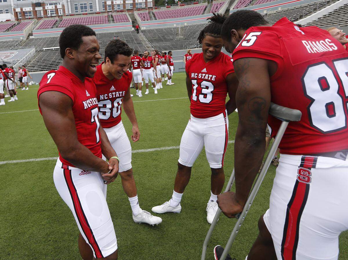 N.C. State's Nyheim Hines (7) laughs with Gavin Locklear (30), Bra'Lon Cherry (13) and Jumichael Ramos (85) during N.C. State football's media day at Carter-Finley Stadium on Aug. 7, 2016.