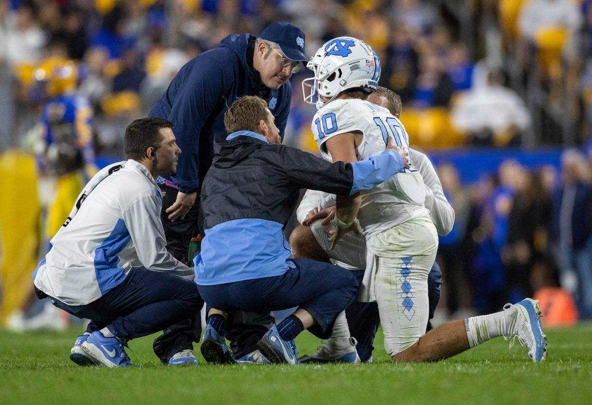 North Carolina quarterback Drake Maye (10) is attended to after taking a hard hit on a roughing the passer penalty by Pitt’s Damon Hayes (50) in the second quarter on Saturday, September 23, 2023 at Acrisure Stadium in Pittsburgh, Pa. Maye missed the next play but did return to finish the quarter.