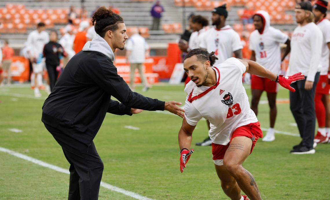 N.C. State wide receiver Anthony Smith, left, works with Josh Crabtree (83) before N.C. State’s game against Clemson at Memorial Stadium in Clemson, S.C., Saturday, Oct. 1, 2022.