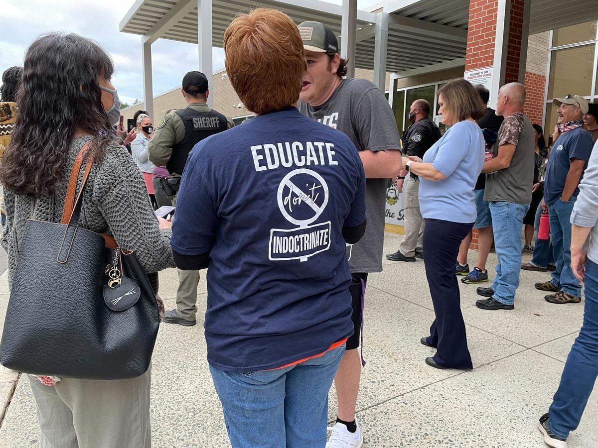 Protesters gather outside the Orange County school board meeting in Hillsborough, NC, on Oct. 11, 2021, as board members consider a resolution opposing “incidents of hostile and racist behavior.”