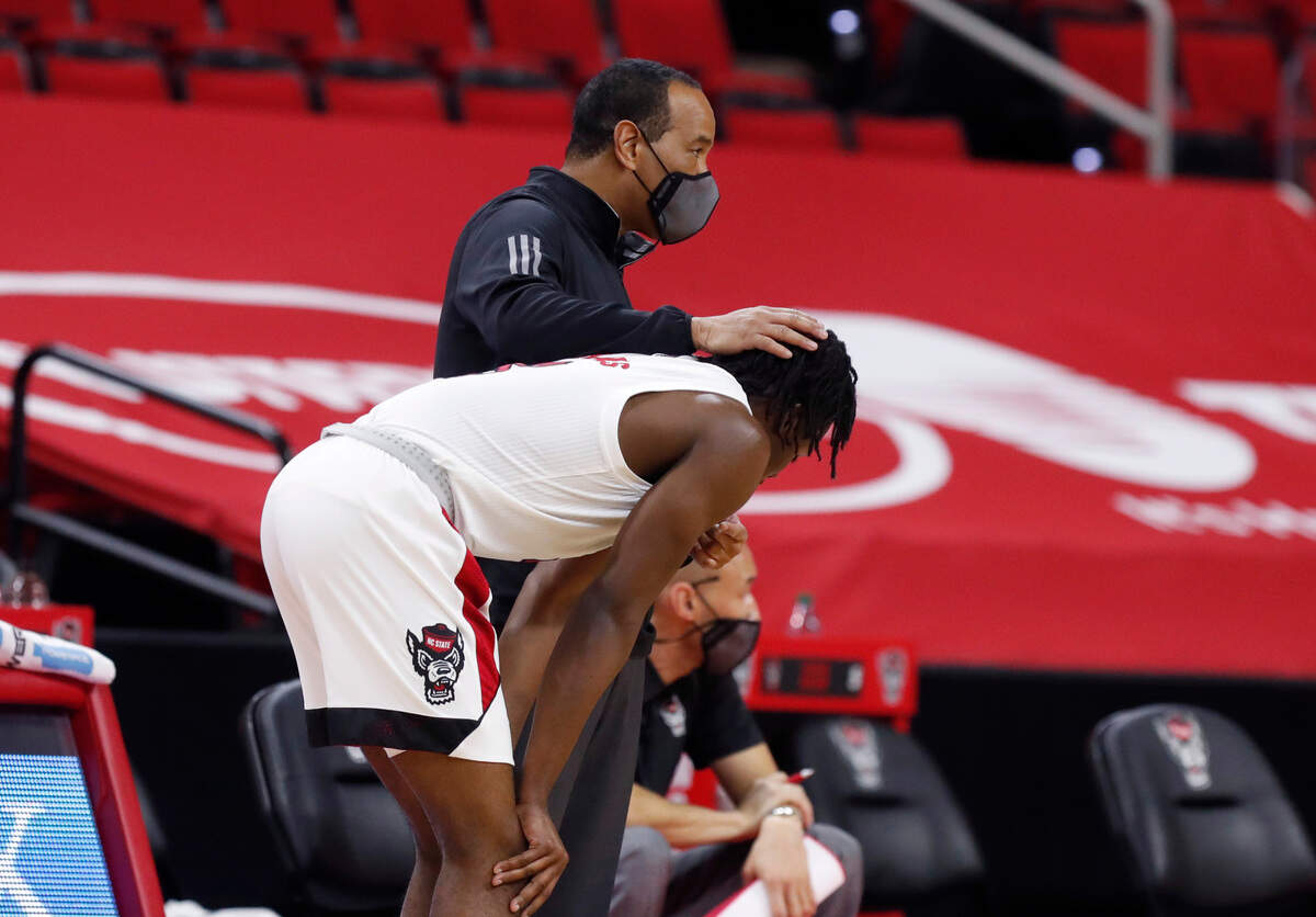 N.C. State head coach Kevin Keatts talks with Cam Hayes (3) during the second half of Virginia’s 64-57 victory over N.C. State at PNC Arena in Raleigh, N.C., Wednesday, February 3, 2021.