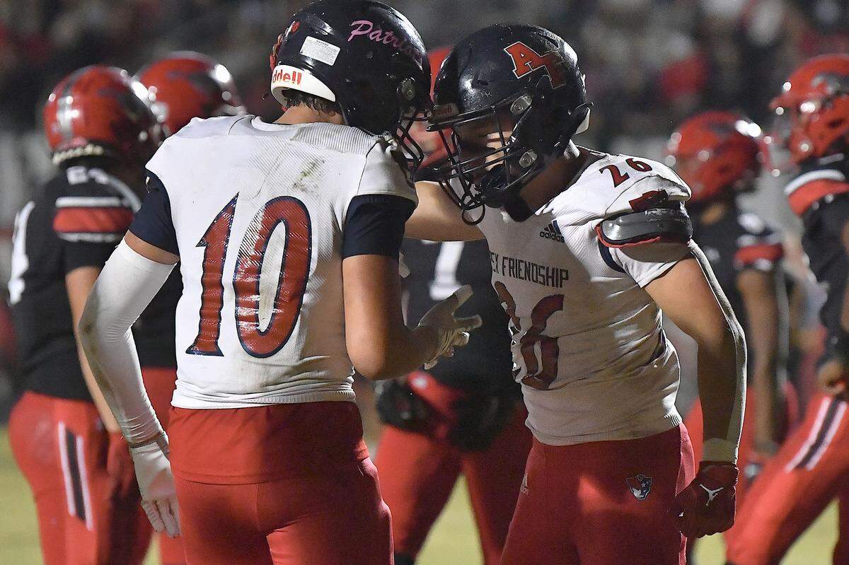 Apex Friendship’s Tino Ramirez (10) congratulates Jaden Avery (26) after his touchdown against Middle Creek during the first half. The Middle Creek Mustangs and the Apex Friendship Patriots met in a football game in Cary, N.C. on October 25, 2024.