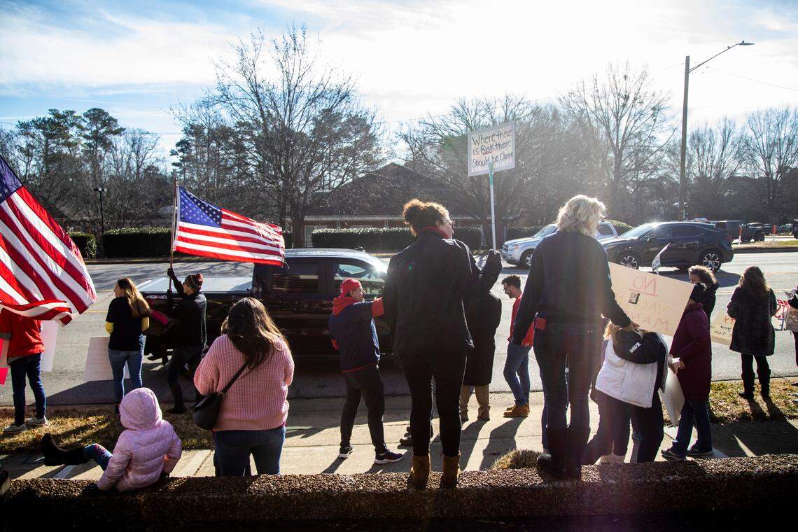 Demonstrators opposed to vaccine requirements protest outside the The N.C. Commission for Public Health in Raleigh Wednesday, Feb. 2, 2022. The commission unanimously voted against a rule-making petition from four UNC System professors to add the COVID vaccine to state immunization requirements for people who are 17 years old or who are entering 12th grade as of July 1.