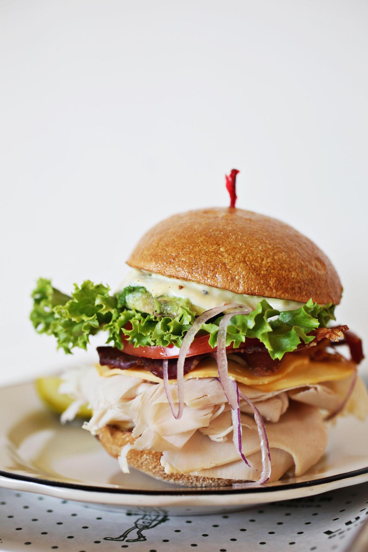 The Roast Turkey is served with smoked gouda, bacon, avocado, leaf lettuce, red onion, tomato and garlic mayo on a kaiser at Luckyâs Delicatessen in downtown Durham.