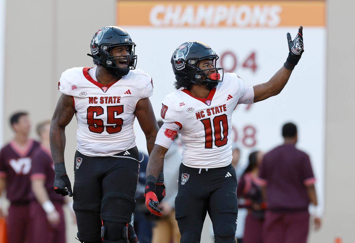 N.C. State’s Jacarrius Peak (65) and KC Concepcion (10) celebrate after Concepcion scored on a three-yard touchdown reception during the first half of N.C. State’s game against Virginia Tech at Lane Stadium in Blacksburg, VA, Saturday, Nov. 18, 2023.