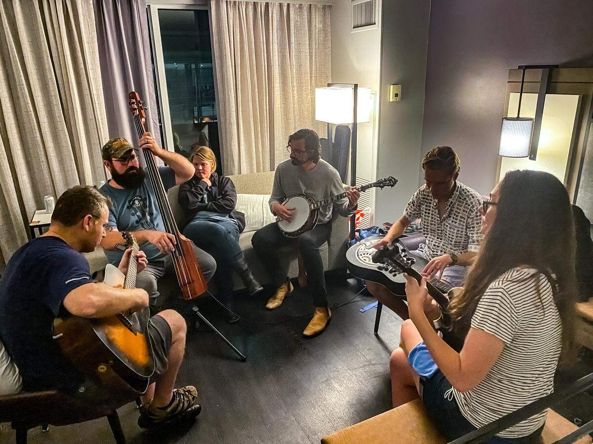 From left to right: Tyler Griffith plays the bass; Tony Watt plays the acoustic guitar,; Eli Gilbert plays the banjo; Kylie Anderson plays the mandolin and her husband, Owen Schinkel, plays the slide guitar in a fourth floor room at the Marriott Raleigh City Center on October 3, 2021.