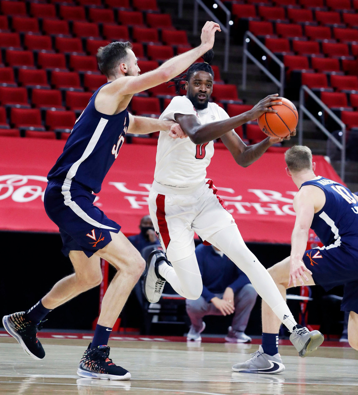 N.C. State’s D.J. Funderburk (0) tries to get around Virginia’s Jay Huff (30) during the first half of N.C. State’s game against Virginia at PNC Arena in Raleigh, N.C., Wednesday, February 3, 2021.