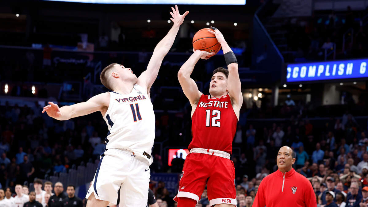 N.C. State’s Michael O’Connell (12) makes a three-pointer as time expires to tie the game in regulation during the Wolfpack’s 72-65 overtime victory over Virginia in the semifinals of the 2024 ACC Men’s Basketball Tournament at Capital One Arena in Washington, D.C., Friday, March 15, 2024. Virginia’s Isaac McKneely (11) defends.