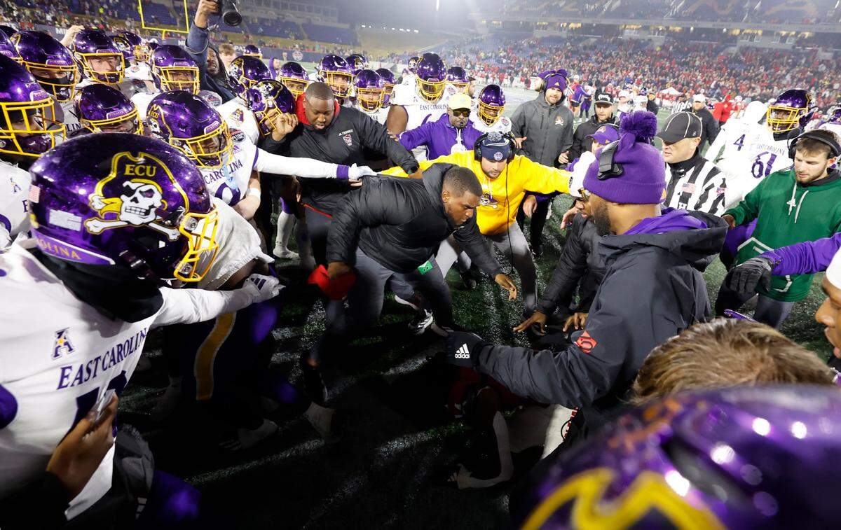 N.C. State safety Rente Hinton (14) is surrounded by East Carolina players during a scuffle near the end of ECU’s 26-21 victory over N.C. State in the Military Bowl at Navy-Marine Corps Memorial Stadium in Annapolis, Md., Saturday, Dec. 28, 2024.