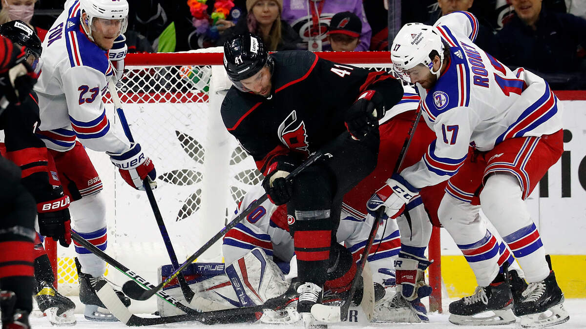 Carolina Hurricanes’ Josh Leivo (41) battles for the puck between New York Rangers’ Adam Fox (23) and Kevin Rooney (17) in front of Rangers goaltender Alexandar Georgiev during the first period of an NHL hockey game in Raleigh, N.C., Friday, Jan. 21, 2022. (AP Photo/Karl B DeBlaker)