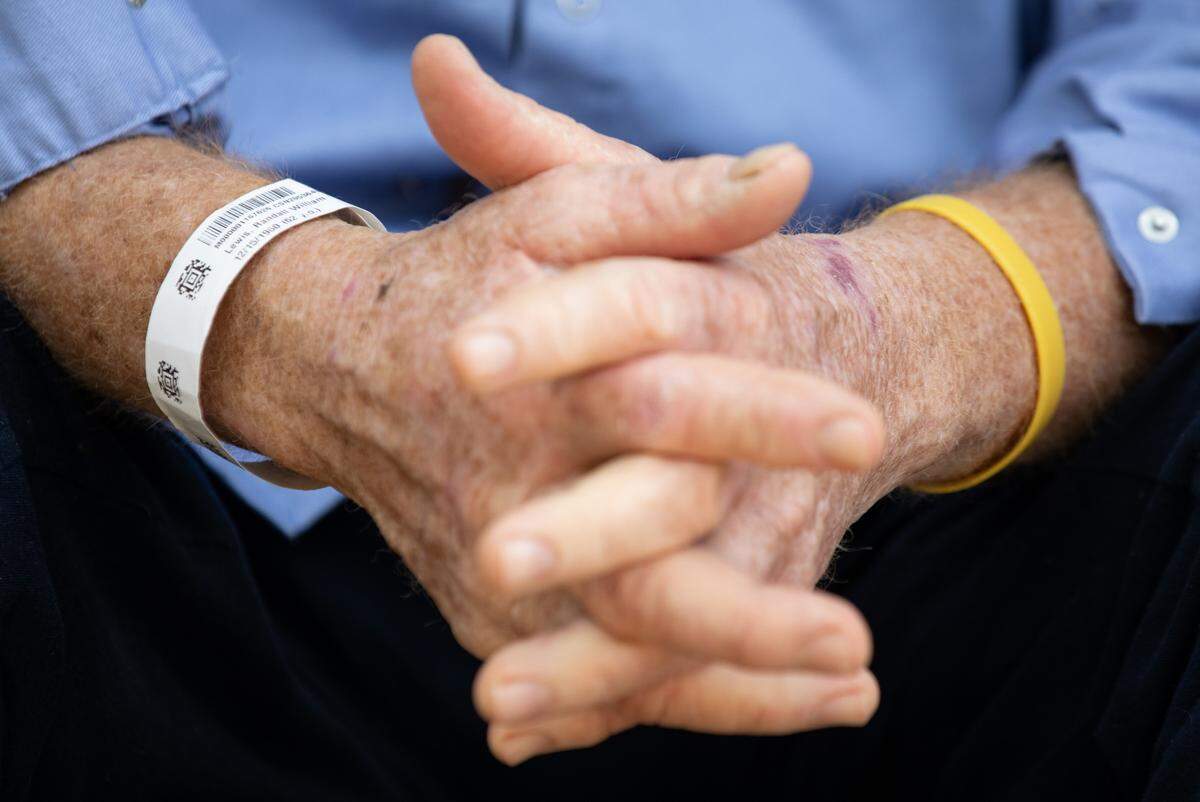 Randy Lewis clasps his hands on the front porch of his house at Ran-Lew Dairy Farm in Snow Camp, N.C. on Friday, June 16, 2023. Lewis spent 26 days in the hospital after being attacked by a black Angus bull on his farm last month. He returned home to Ran-Lew Dairy on June 2, where he has continued his recovery.