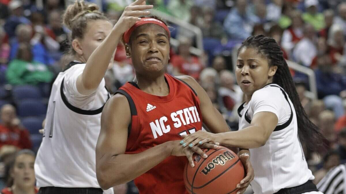 North Carolina State’s Kiara Leslie, center, drives between Louisville’s Kylee Shook, left, and Arica Carter, right, during the second half of an NCAA college basketball game in the Atlantic Coast Conference women’s tournament in Greensboro, N.C., Saturday, March 9, 2019.