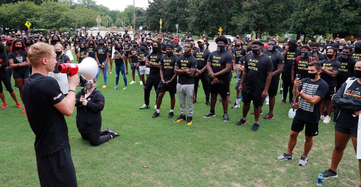 N.C. State athletes, coaches and staff listen to the speakers during a #PackUnited peaceful protest against racial and social injustice outside Holladay Hall on the campus of N.C. State Saturday, Sept. 12, 2020.