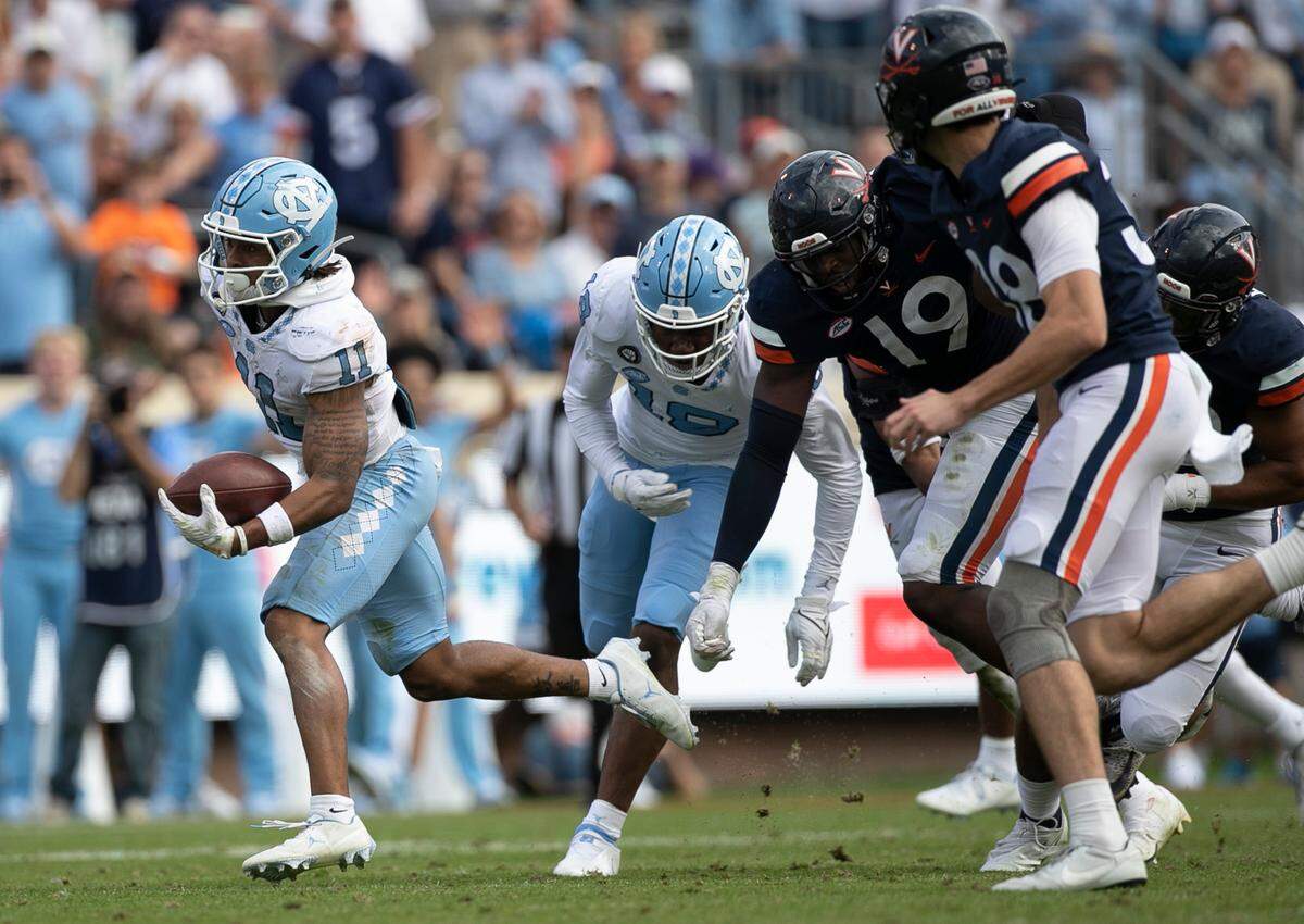 North Carolina’s Josh Downs (11) returns a Virginia punt 38-yards in the fourth quarter on Saturday, November 5, 2022 at Scott Stadium in Charlottesville, Va.