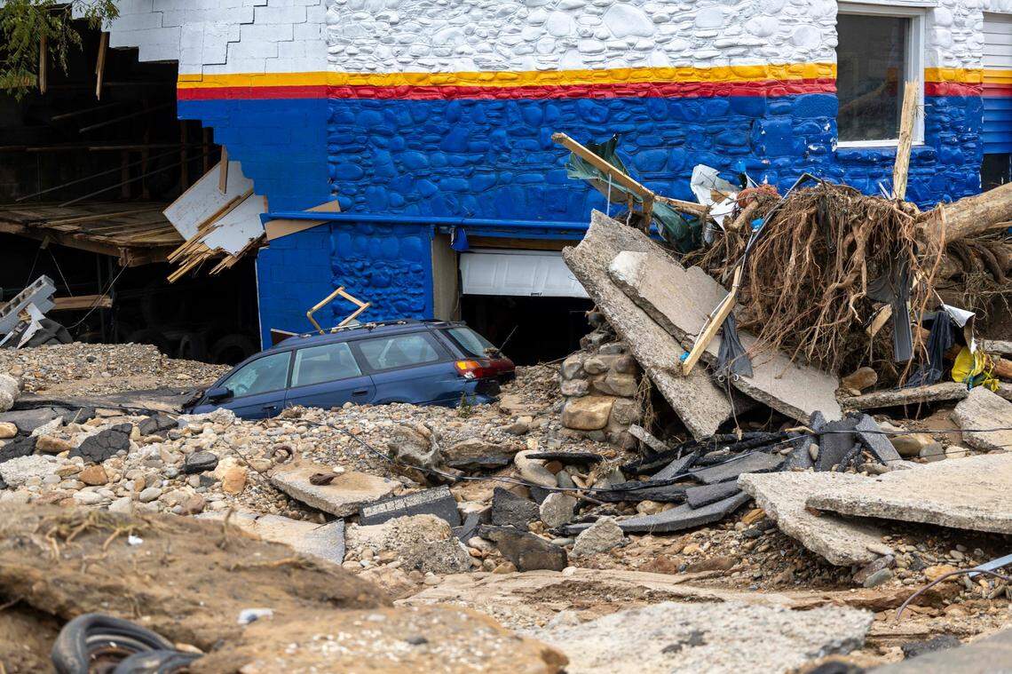 A car is partially buried in mud near the Swannanoa River on Sunday, Sept. 29, 2024. The remnants of Hurricane Helene caused widespread flooding, downed trees, and power outages in western North Carolina.