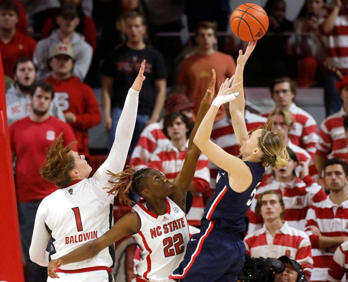 UConn’s Paige Bueckers shoots over N.C. State’s River Baldwin and Saniya Rivers during the second half of the Wolfpack’s 92-81 win on Sunday, Nov. 12, 2023, at Reynolds Coliseum in Raleigh, N.C.