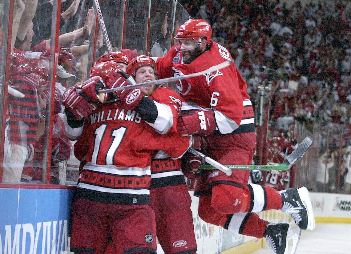 Eric Staal (12) and Bret Hedican (6) jump on Justin Williams (11) after he scored an empty netter late in the third period to seal the win, and the Stanley Cup, for the Canes. The Carolina Hurricanes beat the Edmonton Oilers 3-1 in Game 7 of the Stanley Cup finals in 2006.
