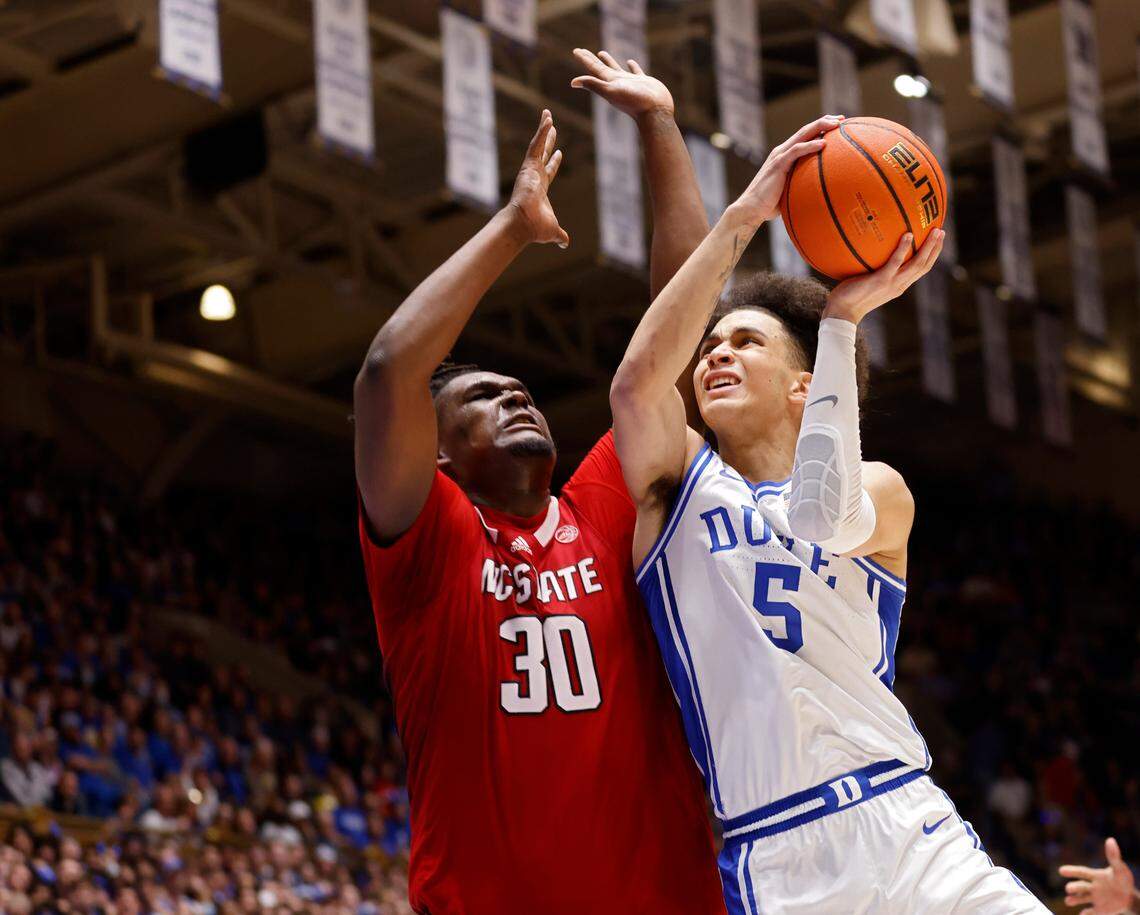 Duke’s Tyrese Proctor drives by N.C. State’s D.J. Burns Jr. during the second half of Duke’s 71-67 win over N.C. State on Tuesday, Feb. 28, 2023, at Cameron Indoor Stadium in Durham, N.C.