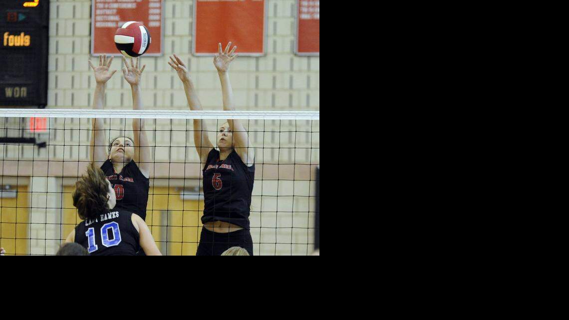 Middle Creek’s Cali Page (left) and Sam Smith (6) go up for a block against Triton's Dahlia Guin's (10) spike. The Triton Hawks volleyball team played the Middle Creek Mustangs in Apex on Tuesday, August 26, 2014. Middle Creek won 3-2.
