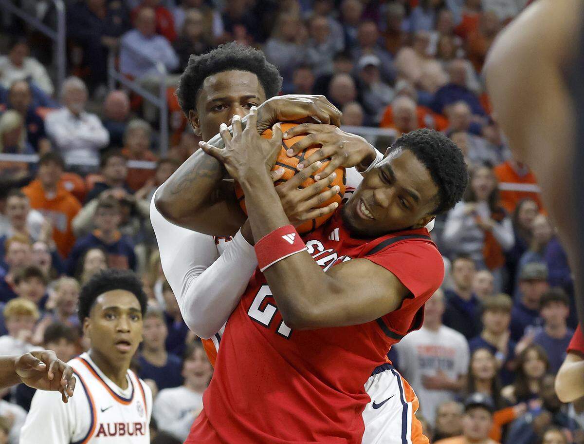 Auburn’s Kevin Overton and N.C. State’s Terrance Arceneaux battle for possession during the first half of the Wolfpack’s game in the ACC/SEC Challenge on Wednesday, Dec. 3, 2025, at Neville Arena in Auburn, Ala. 