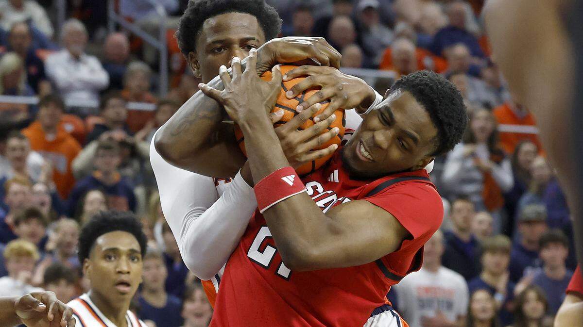 Auburn’s Kevin Overton and N.C. State’s Terrance Arceneaux battle for possession during the first half of the Wolfpack’s game in the ACC/SEC Challenge on Wednesday, Dec. 3, 2025, at Neville Arena in Auburn, Alabama.