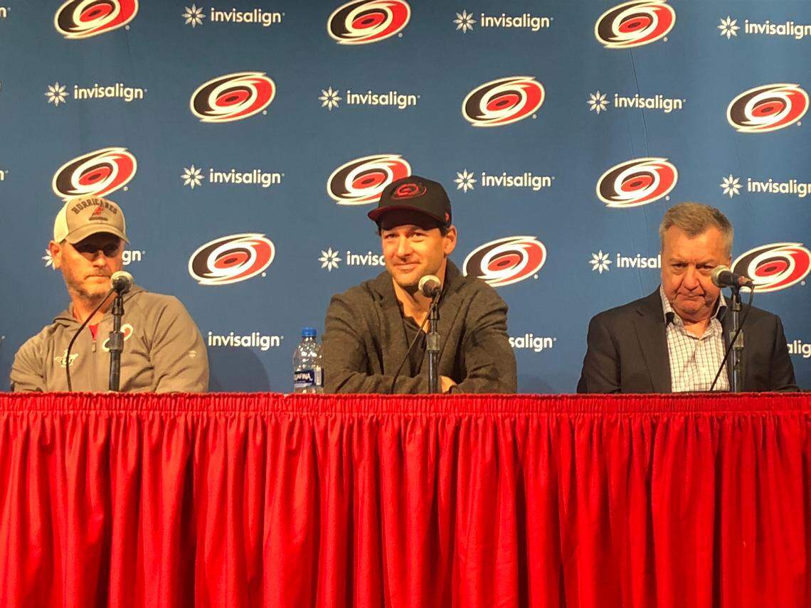 Justin Williams, center, discusses his return to the Carolina Hurricanes while flanked by general manager Don Waddell, right, and owner Tom Dundon, left, at PNC Arena on Wednesday.