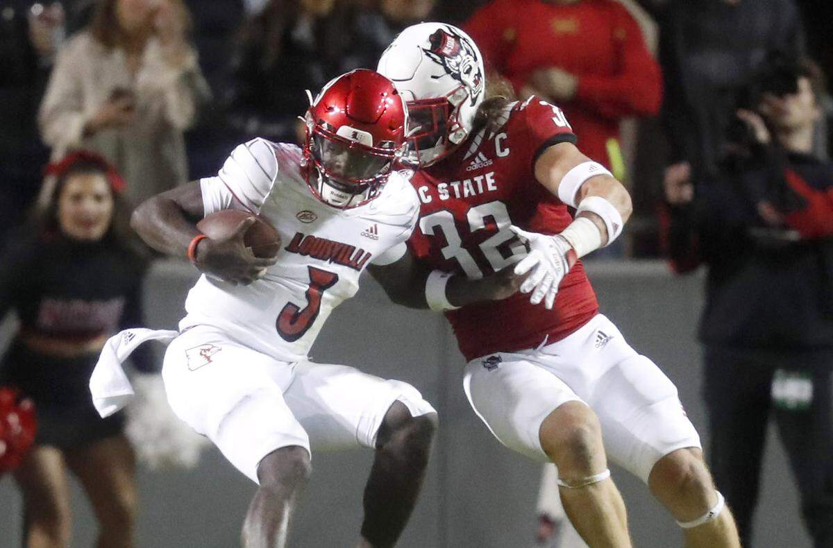 Louisville quarterback Malik Cunningham (3) is tackled by N.C. State linebacker Drake Thomas (32) during the first half of N.C. State’s game against Louisville at Carter-Finley Stadium in Raleigh, N.C., Saturday, October 30, 2021.
