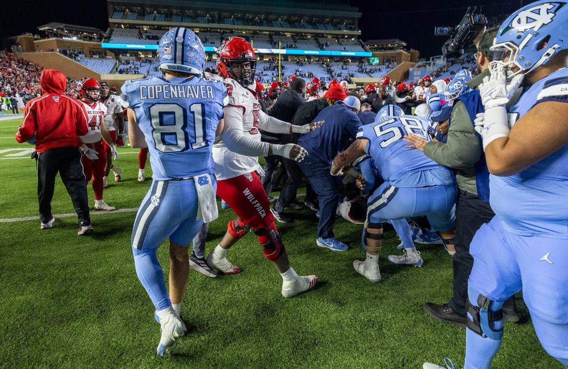 North Carolina tight end John Copenhaver (81) mixes it up with N.C. State offensive guard Timothy McKay (52) during an altercation between the team following the Wolfpack’s 35-30 victory on Saturday, November 30, 2024 at Kenan Stadium in Chapel Hill, N.C.