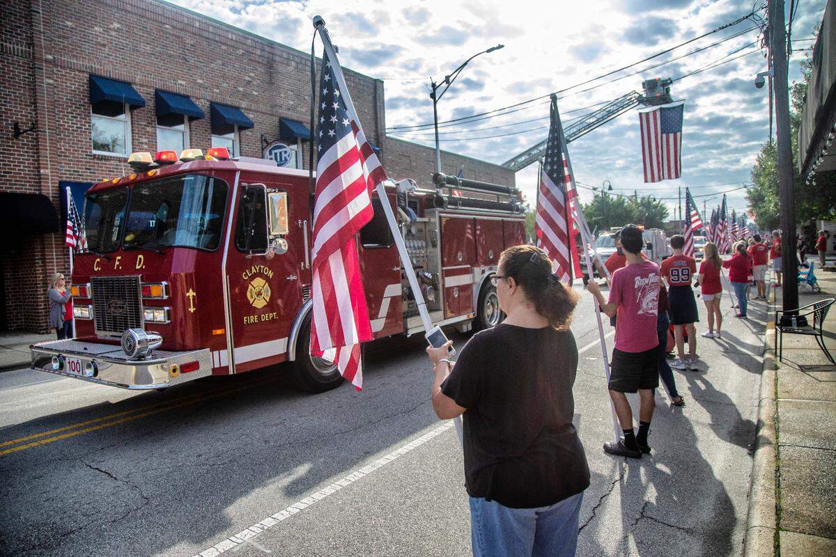 Hundreds line Main Street in Clayton Monday morning, Sept. 28, 2020 to pay respect to Clayton Fire Department Deputy Chief Jason Dean who died of COVID-19 complications. The funeral procession included dozens of emergency vehicles.