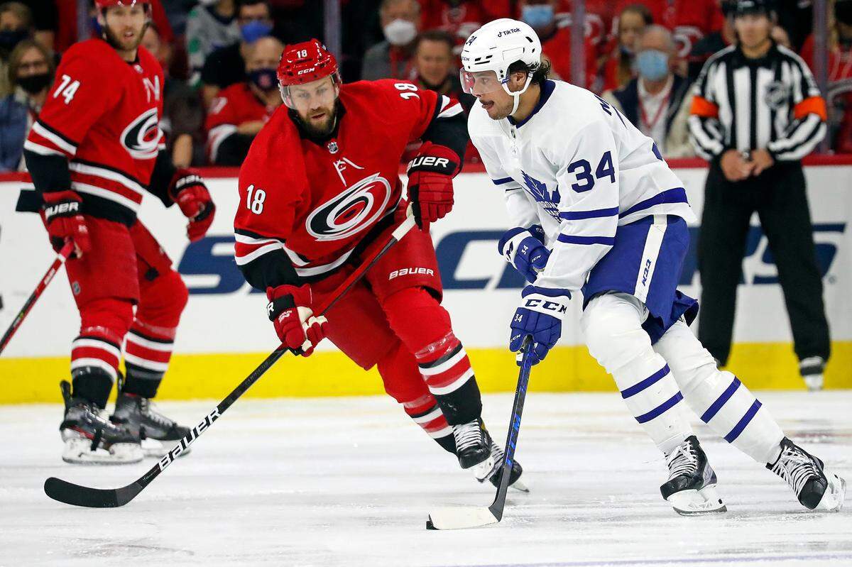 Toronto Maple Leafs’ Auston Matthews (34) is pressured by Carolina Hurricanes’ Derek Stepan (18) during the second period of an NHL hockey game in Raleigh, N.C., Monday, Oct. 25, 2021. (AP Photo/Karl B DeBlaker)