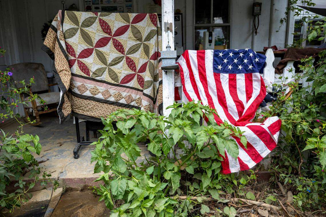 A quilt and an American Flag are hung out to dry on Friday, October 4, 2024 on the front porch of Hot Springs Rafting Company after the historic structure was flooded by Spring Creek during Hurricane Helene.