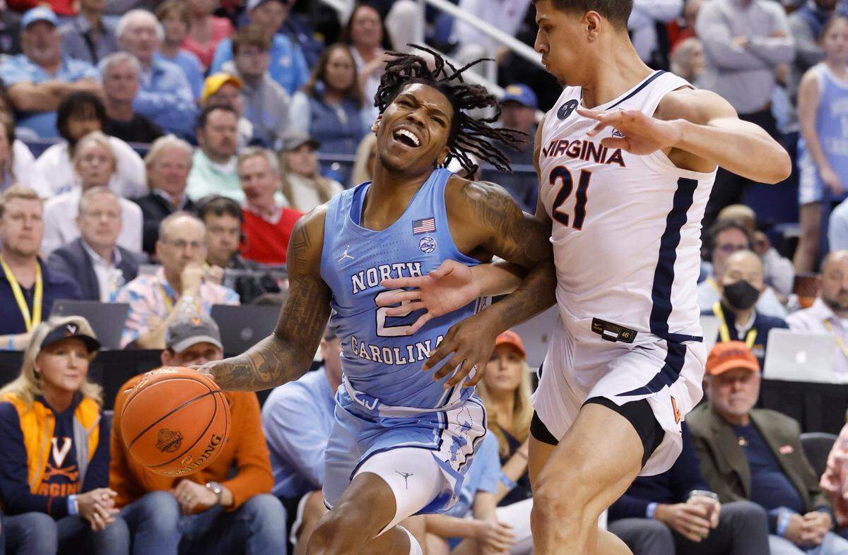 North Carolina’s Caleb Love (2) tries to get around Virginia’s Kadin Shedrick (21) during the first half of UNC’s game against Virginia in the quarterfinals of the ACC Men’s Basketball Tournament in Greensboro, N.C., Thursday, March 9, 2023.